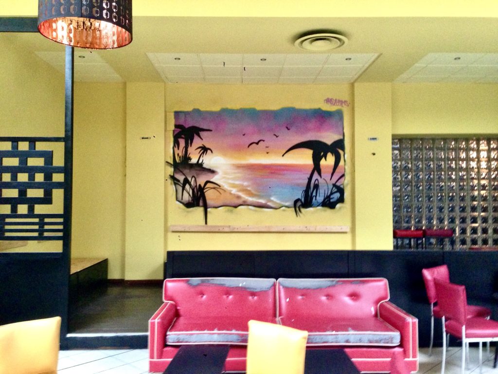 Murales di un paesaggio marino al tramonto sulla parete di un soggiorno