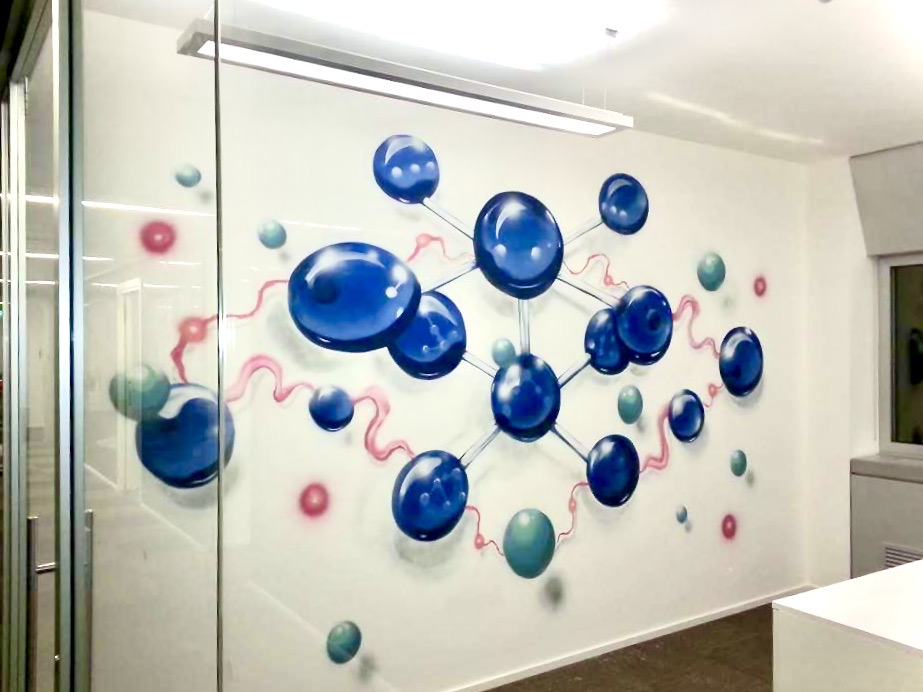 Murales decorativo con motivo a molecole blu sulla parete di un ufficio realizzato dall'artista Foskia